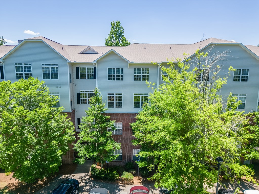 a large white building with trees in front of it