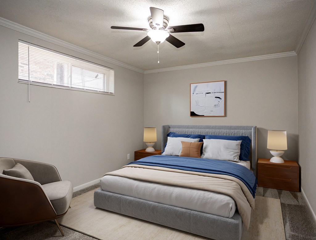 A bedroom with a bed, chair, and ceiling fan.