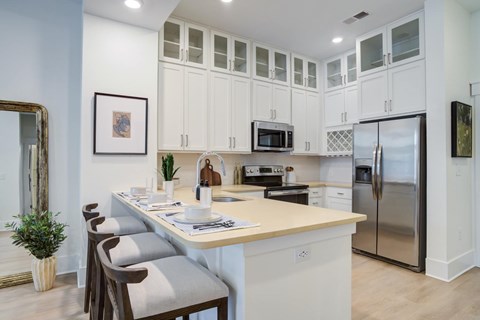 A kitchen with a table and chairs and a fridge.