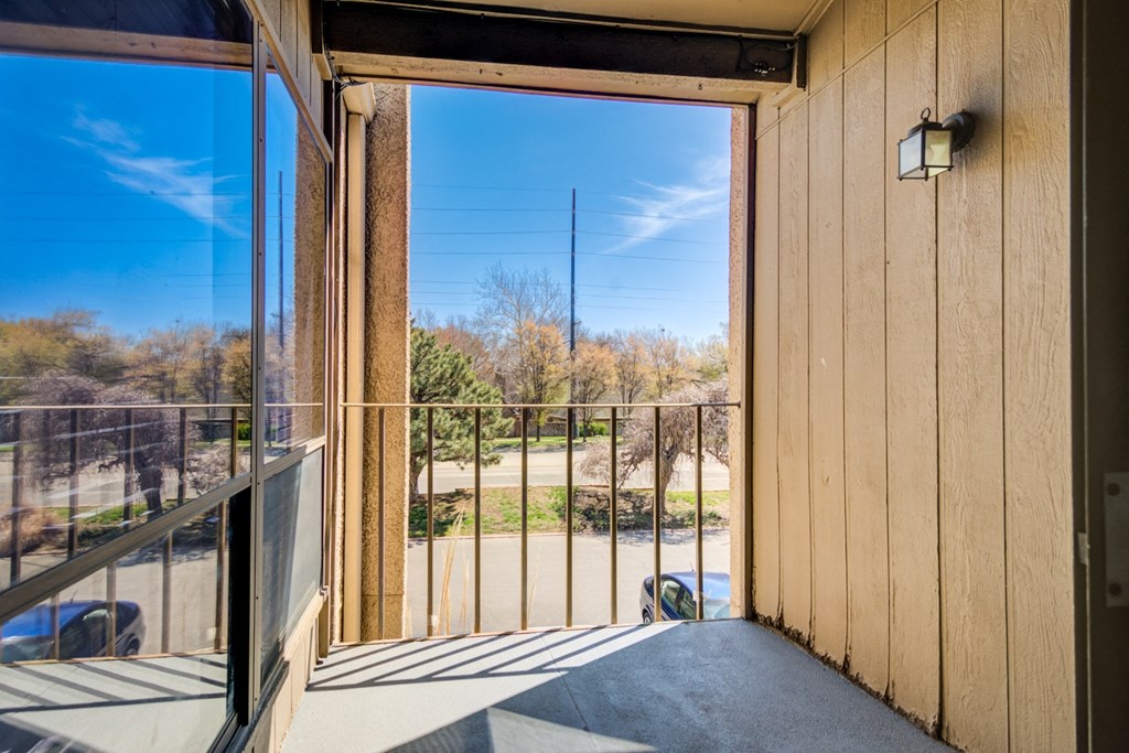 a balcony with a view of a yard and a glass door