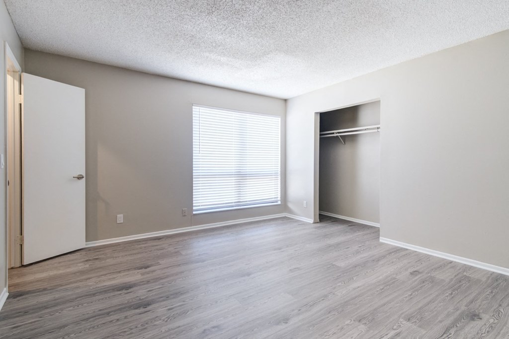 an empty living room with a closet and a window