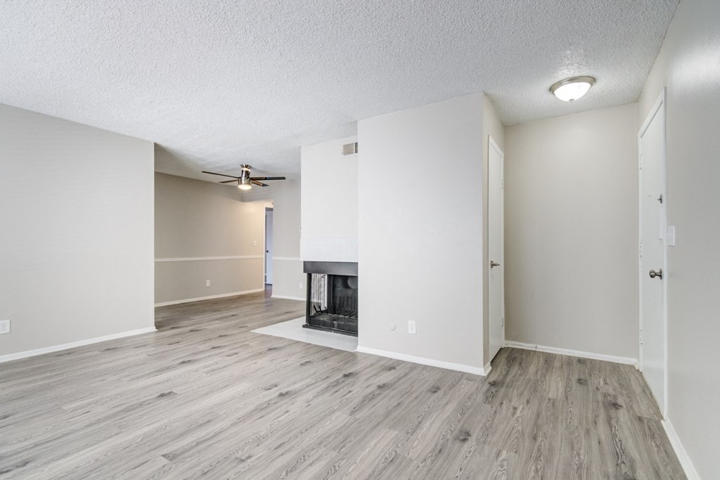 an empty living room with a fireplace and white walls