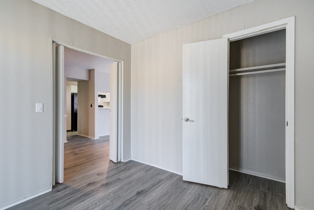 an empty room with white walls and sliding closet doors