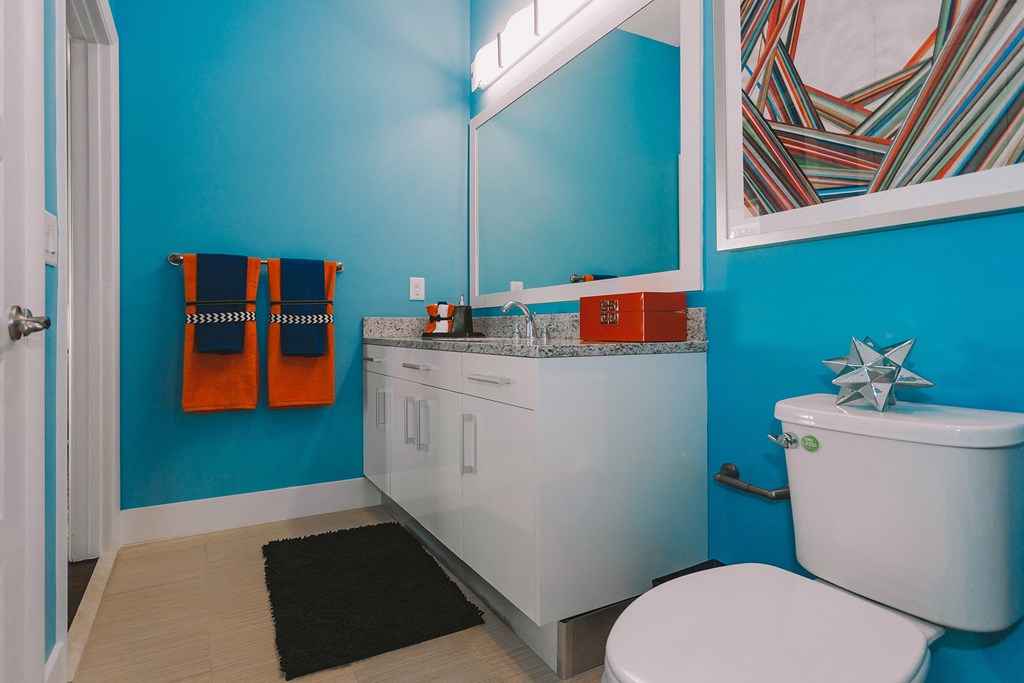 a bathroom with blue walls and a white toilet and sink