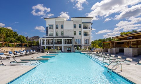 A large swimming pool in front of a multi-story building.