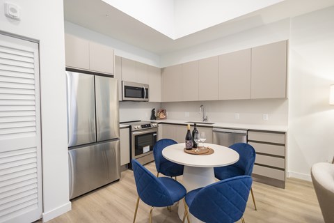 A kitchen with a table and chairs.