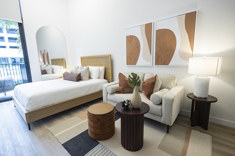 A modern bedroom with a large bed and a white couch.
