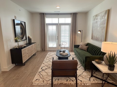 A living room with a brown leather chair and a green sofa.