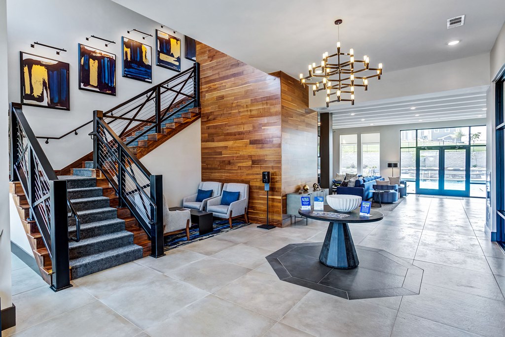 a lobby with a staircase and a table and chairs