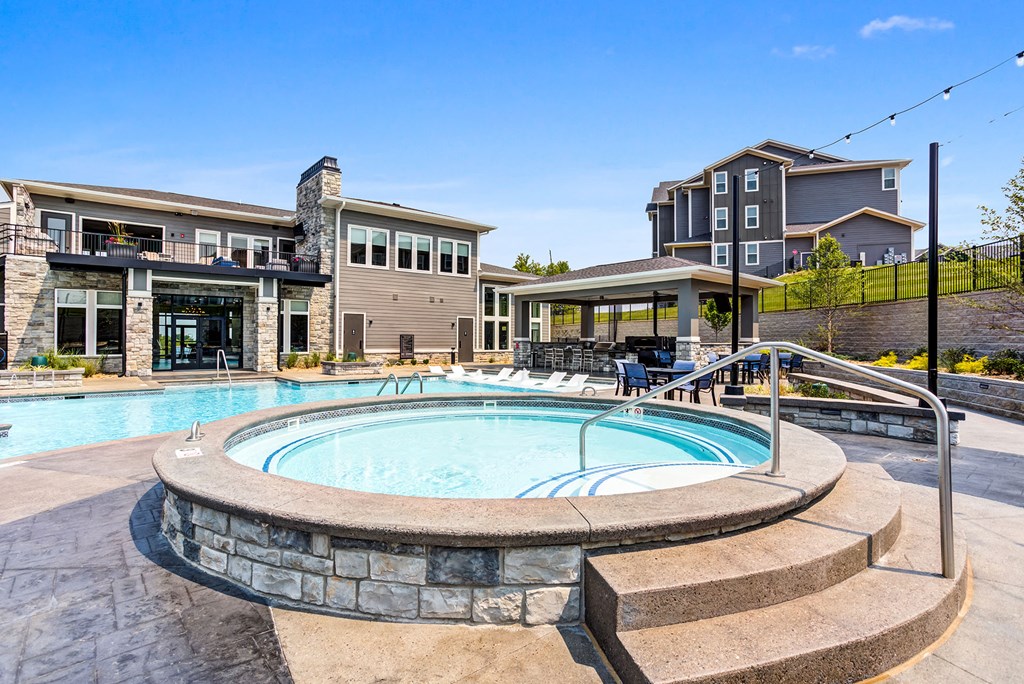 a swimming pool with stairs around it with a building in the background