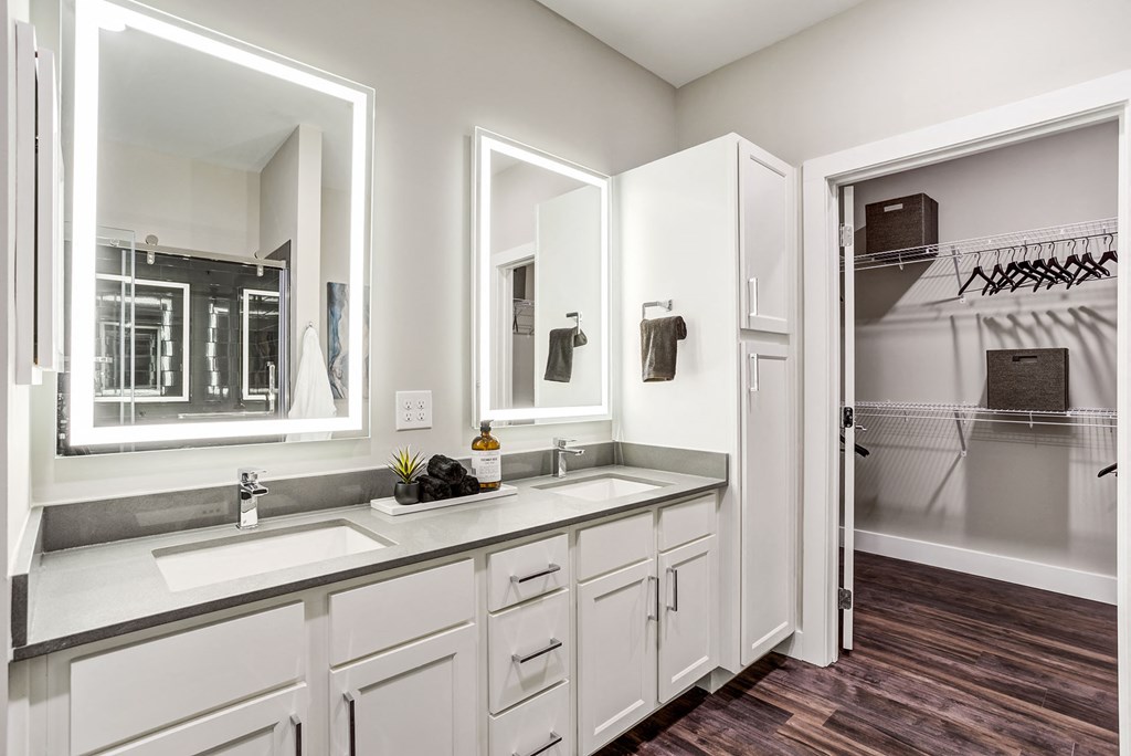 a bathroom with white cabinets and a sink and a mirror