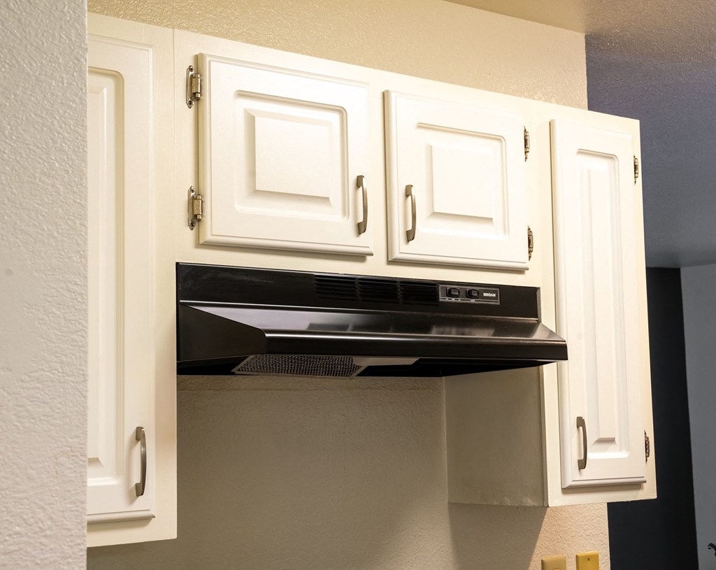 a kitchen with white cabinets and an oven and a microwave