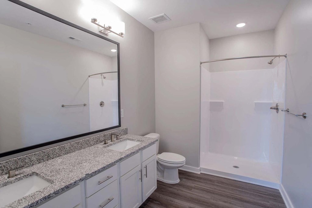 A bathroom with a toilet, sink, and shower.