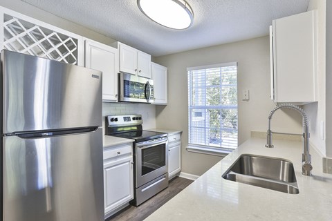 a kitchen with white cabinets and stainless steel appliances