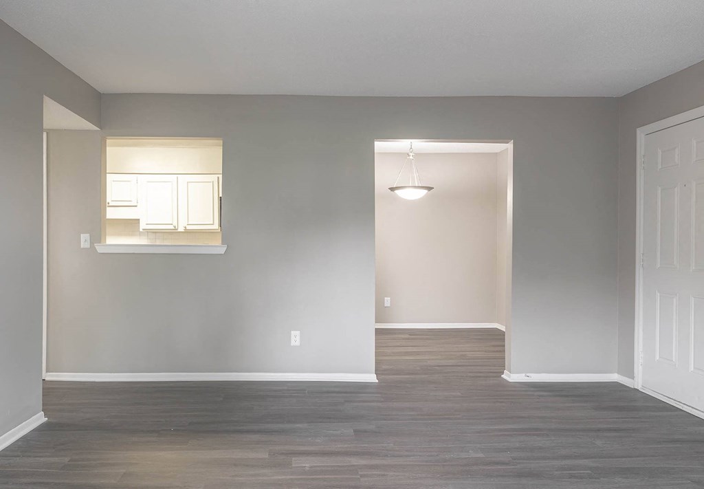 an empty room with a white door and a window