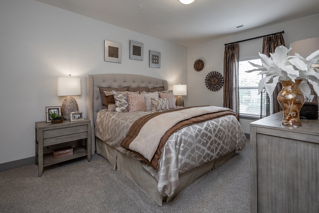 a bedroom with a bed and two nightstands and a window