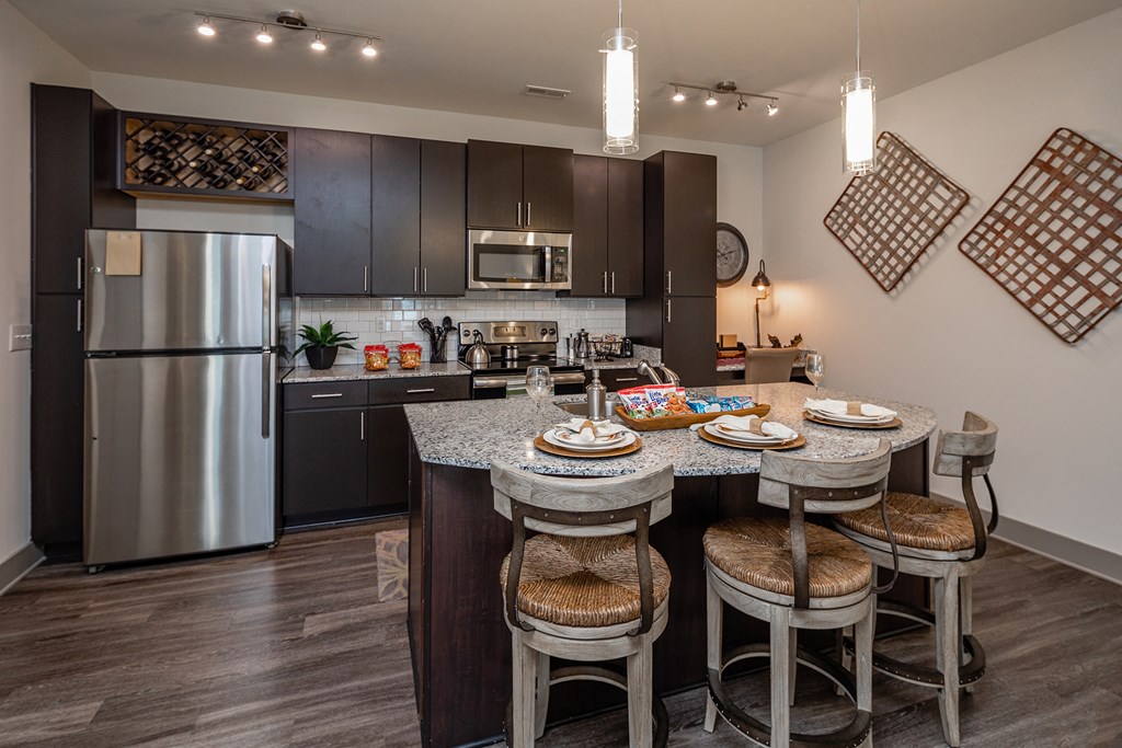 redesigned kitchen with stainless steel appliances and a granite island with stools