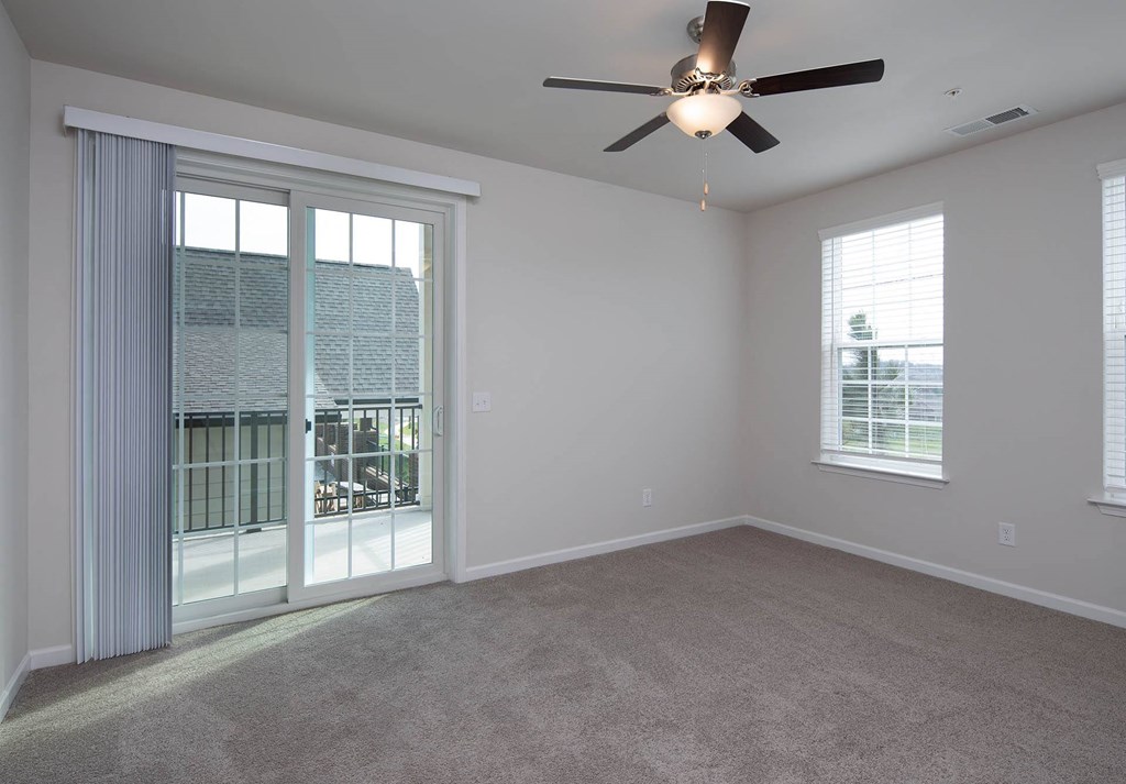 an empty bedroom with a ceiling fan