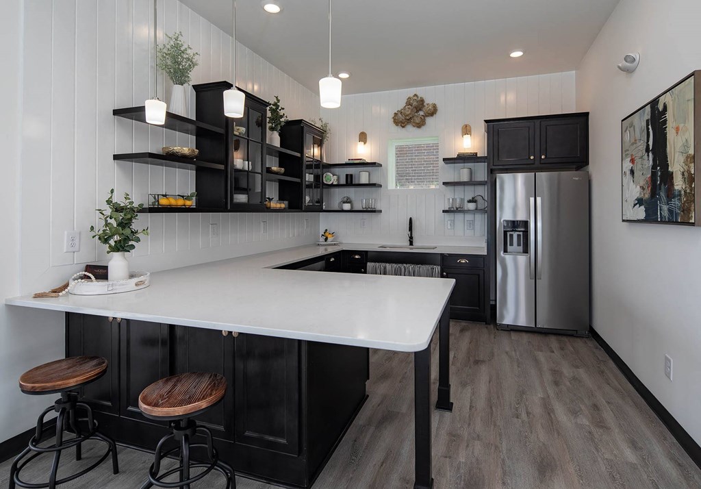 a kitchen with white countertops and black cabinets