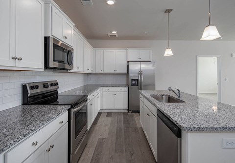 a kitchen with marble counter tops and white cabinets