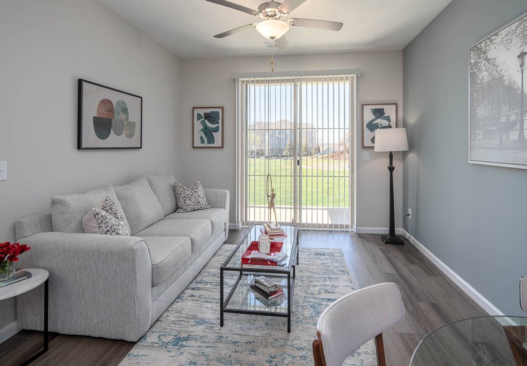 a living room with a large window and a ceiling fan