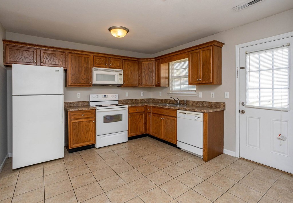 a kitchen with wooden cabinets and white appliances