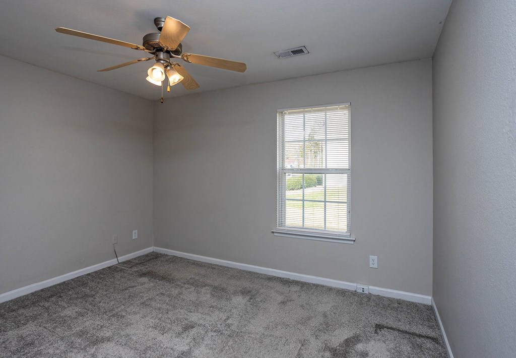 a bedroom with a ceiling fan and a window