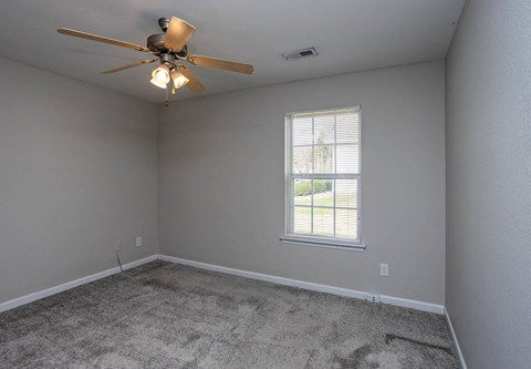 a bedroom with a ceiling fan and a window