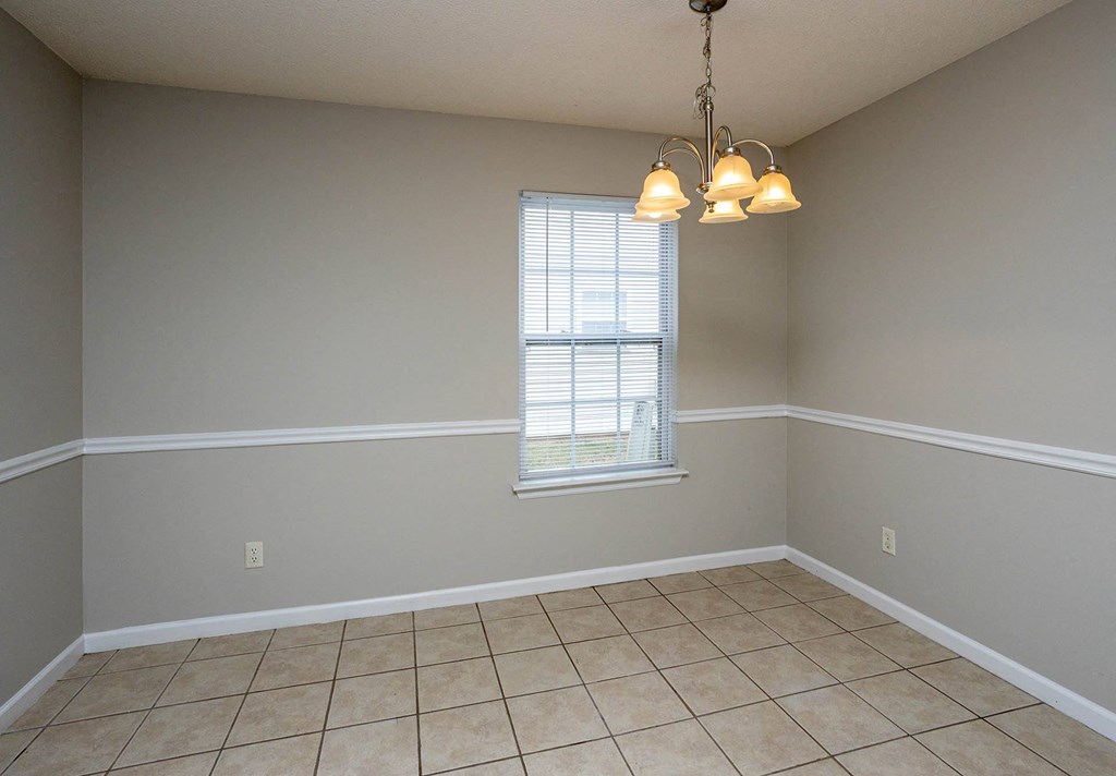 an empty dining room with a chandelier