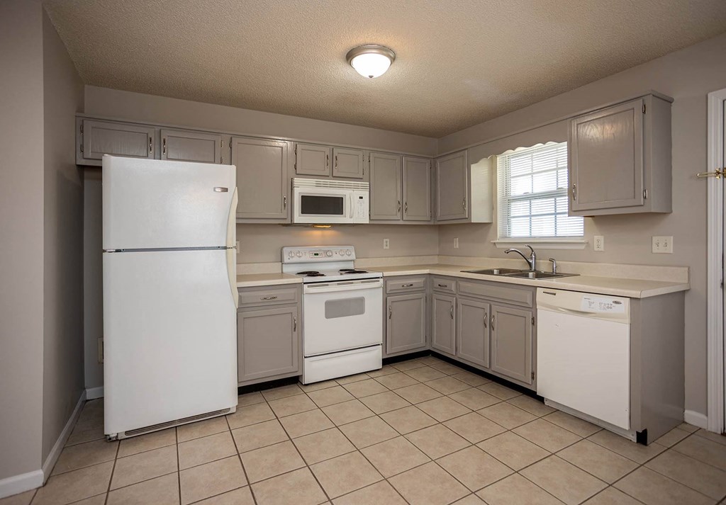 a kitchen with white appliances and gray cabinets