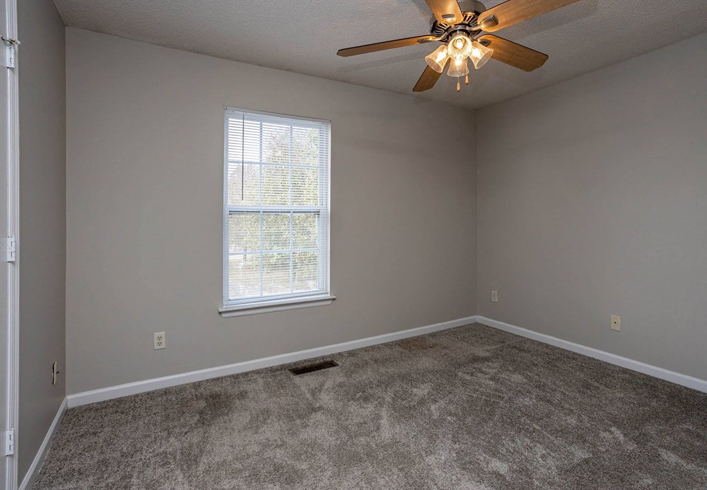 a bedroom with a ceiling fan and a window