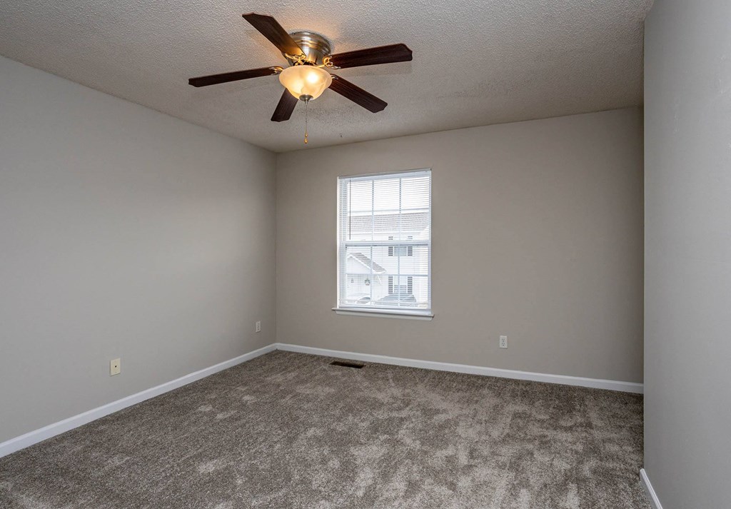 a bedroom with a ceiling fan and a window
