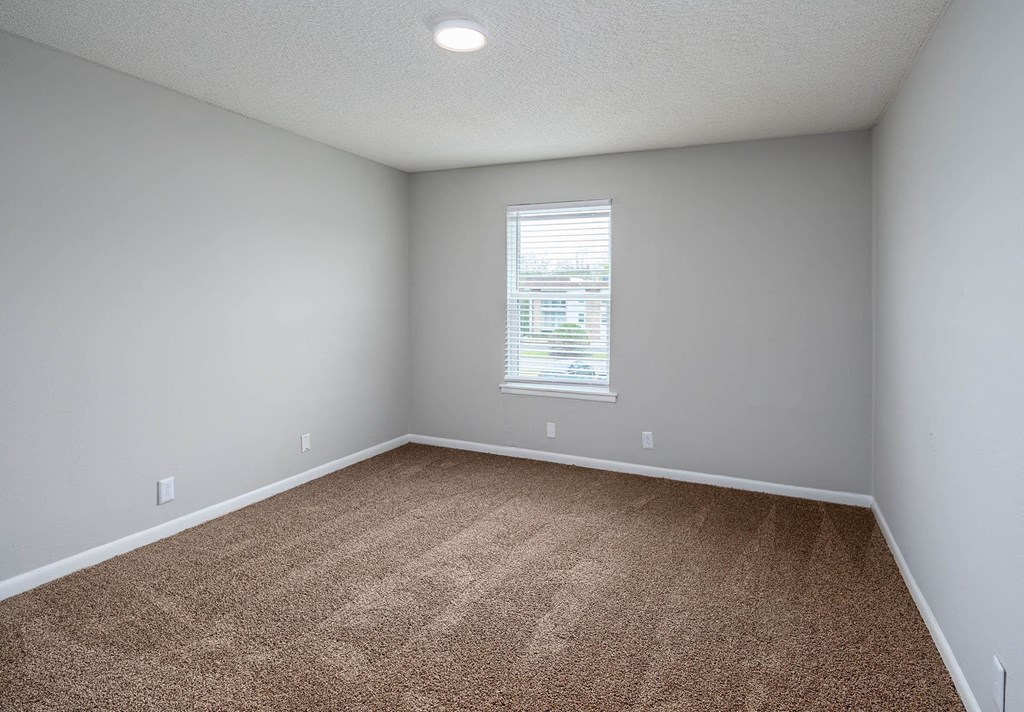 a bedroom with gray walls and a window