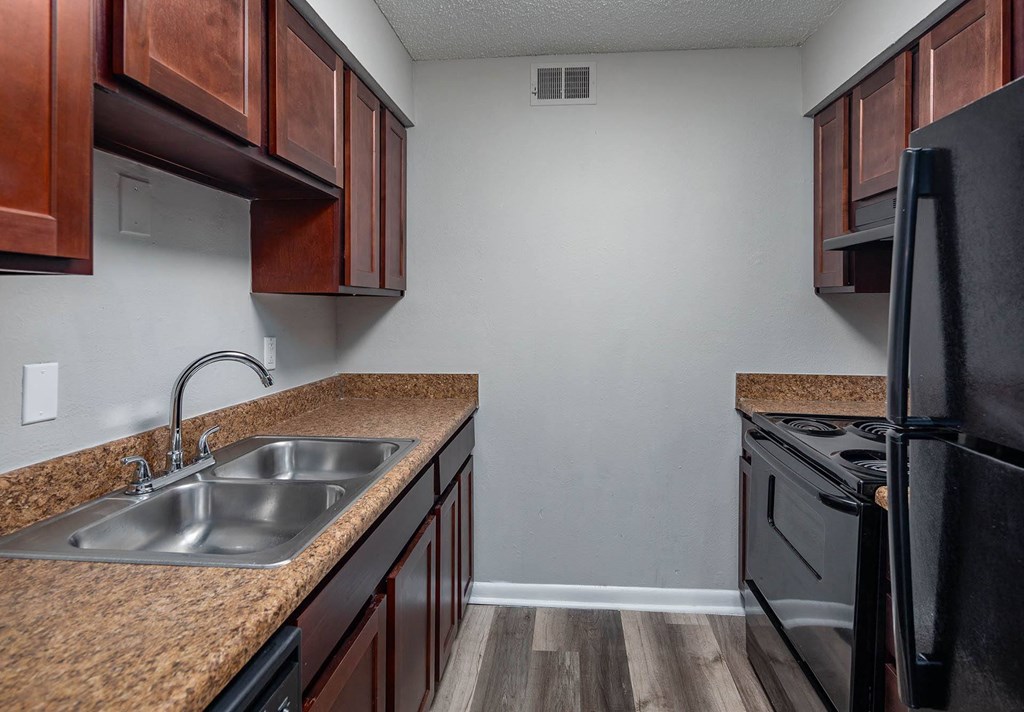 a kitchen with black appliances and brown cabinets