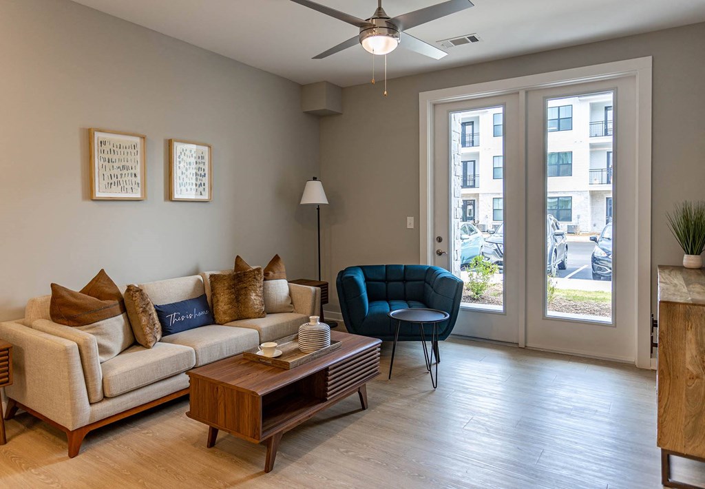 a living room with sliding glass doors and a ceiling fan