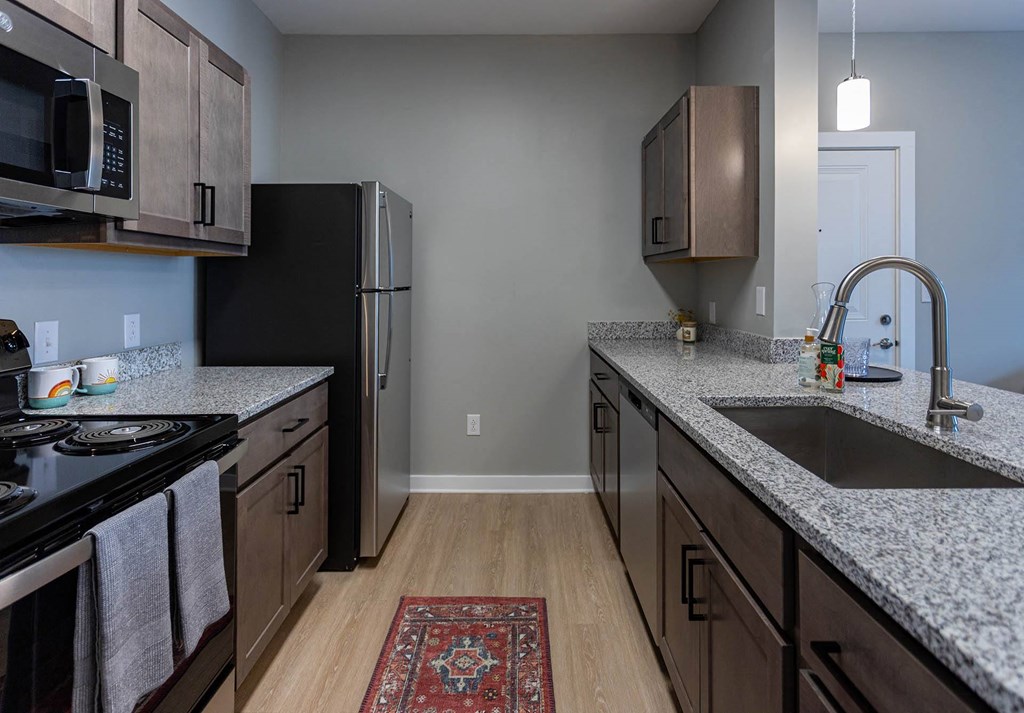 kitchen with granite countertops at the district flats apartments in lenexa, ks