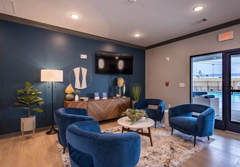 a living room with blue chairs and a tv