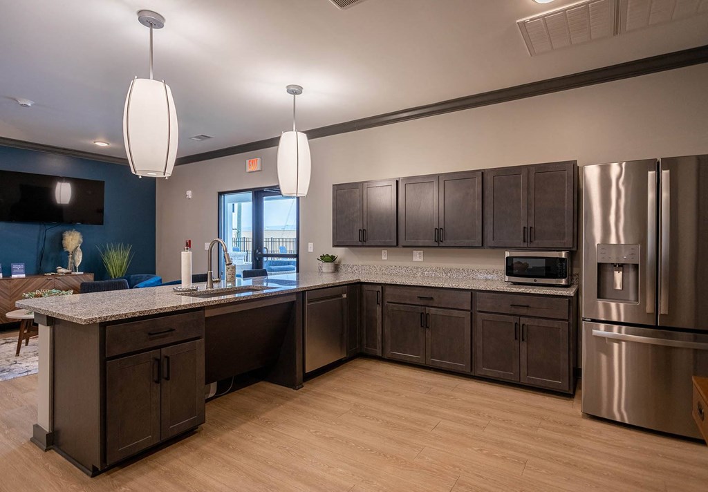 a kitchen with dark cabinets and a large island with granite countertops