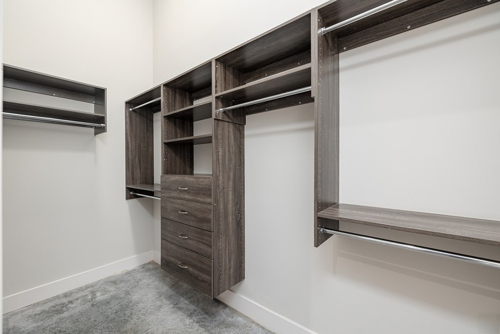 A walk-in closet with a sliding door and shelves.