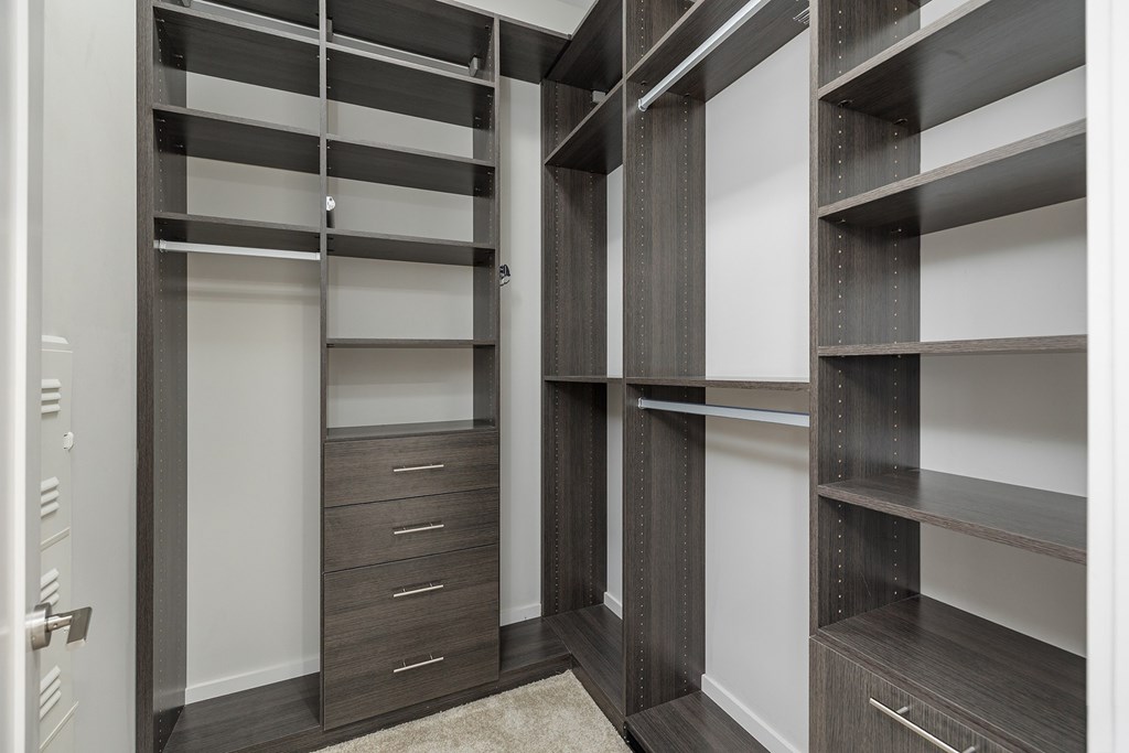 A walk-in closet with shelves and drawers.