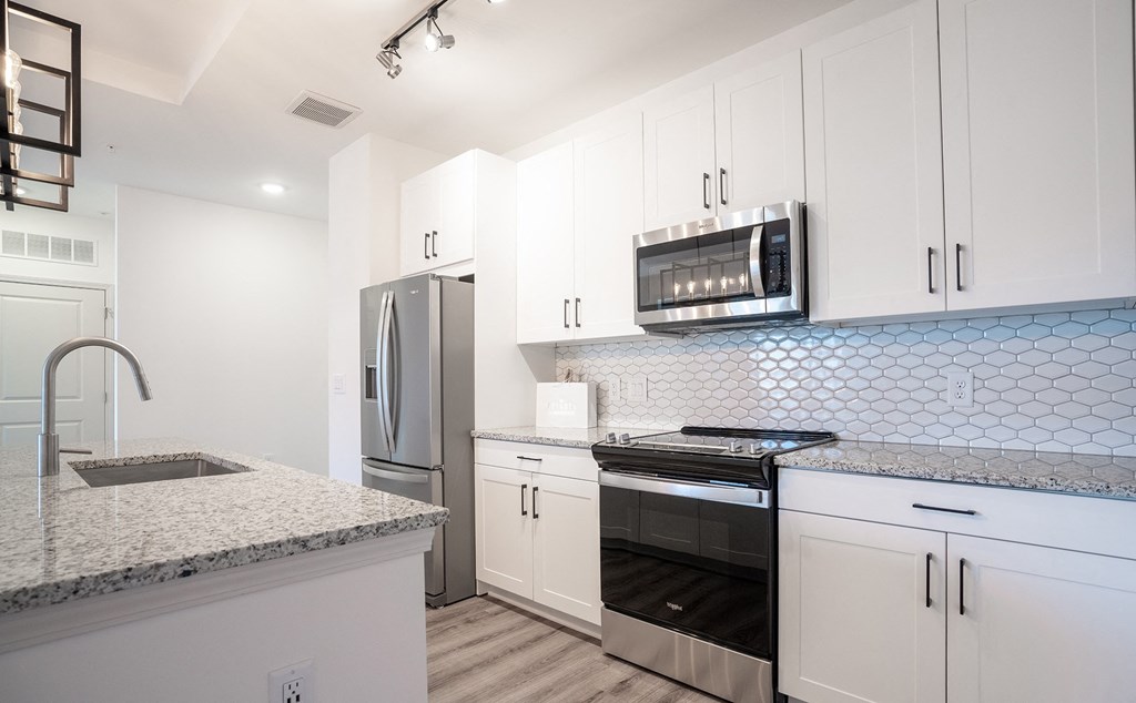 a kitchen with white cabinets and stainless steel appliances
