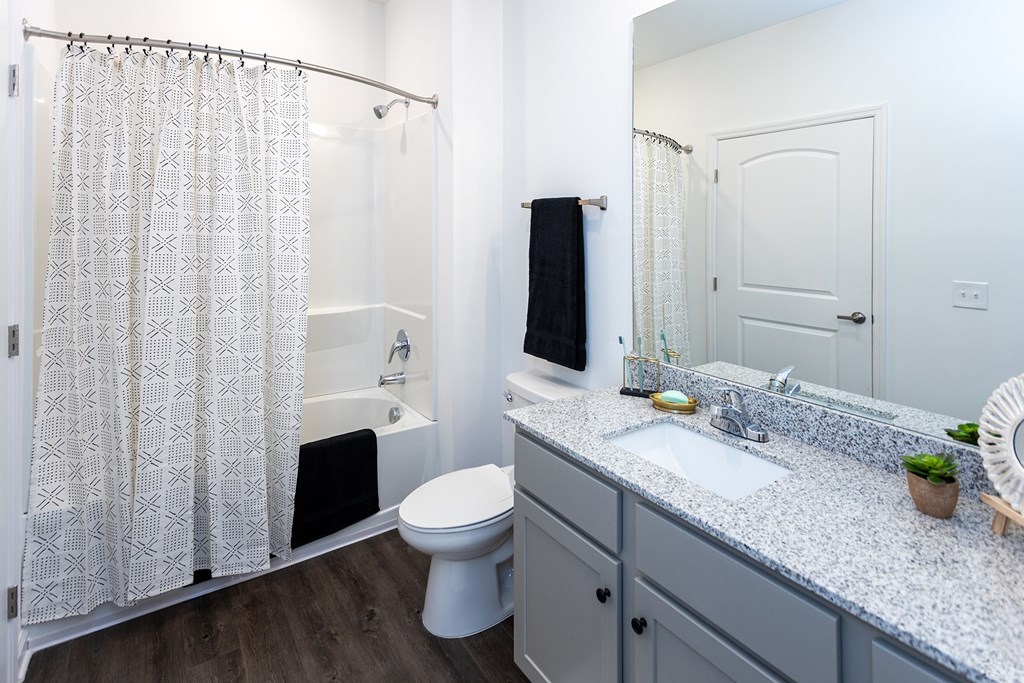 A white bathroom with a toilet, sink, and shower.