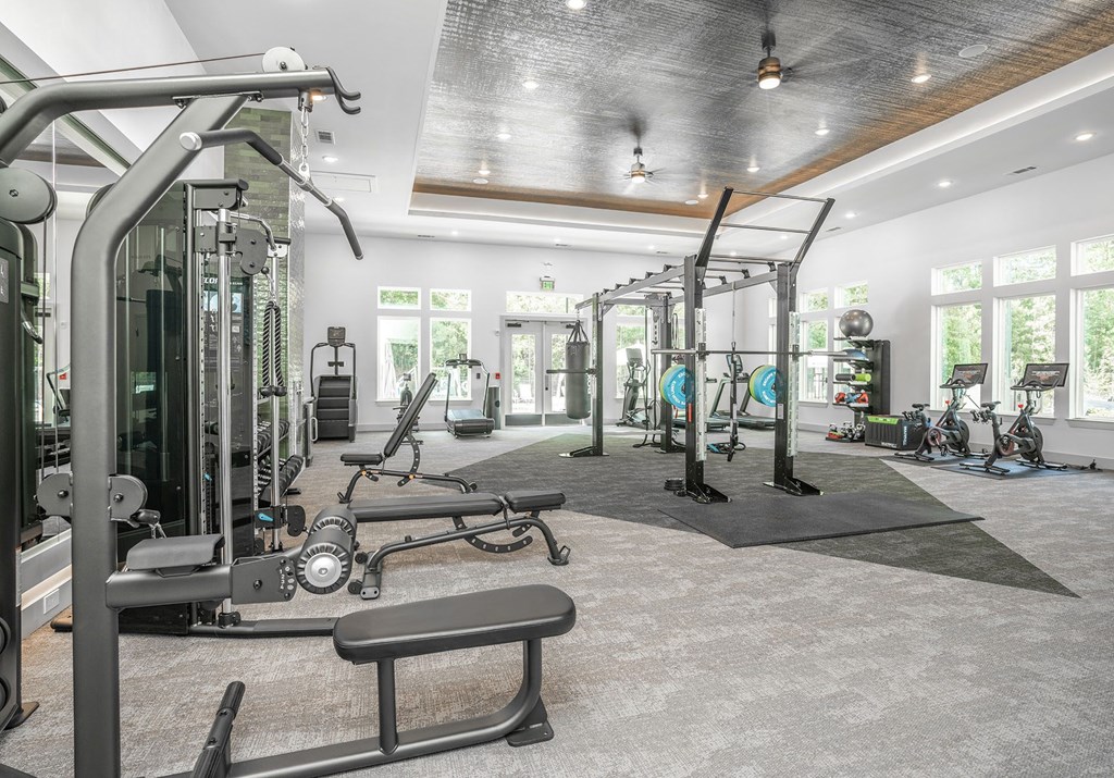 a gym with weights and other equipment in a building with windows