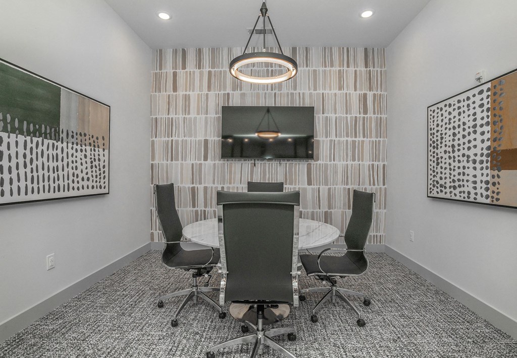 a conference room with a table and chairs and a television