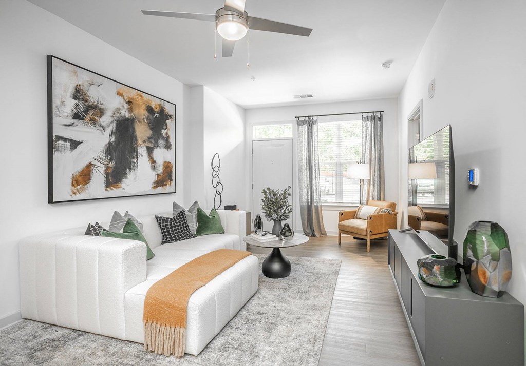 a living room with a white couch and a ceiling fan