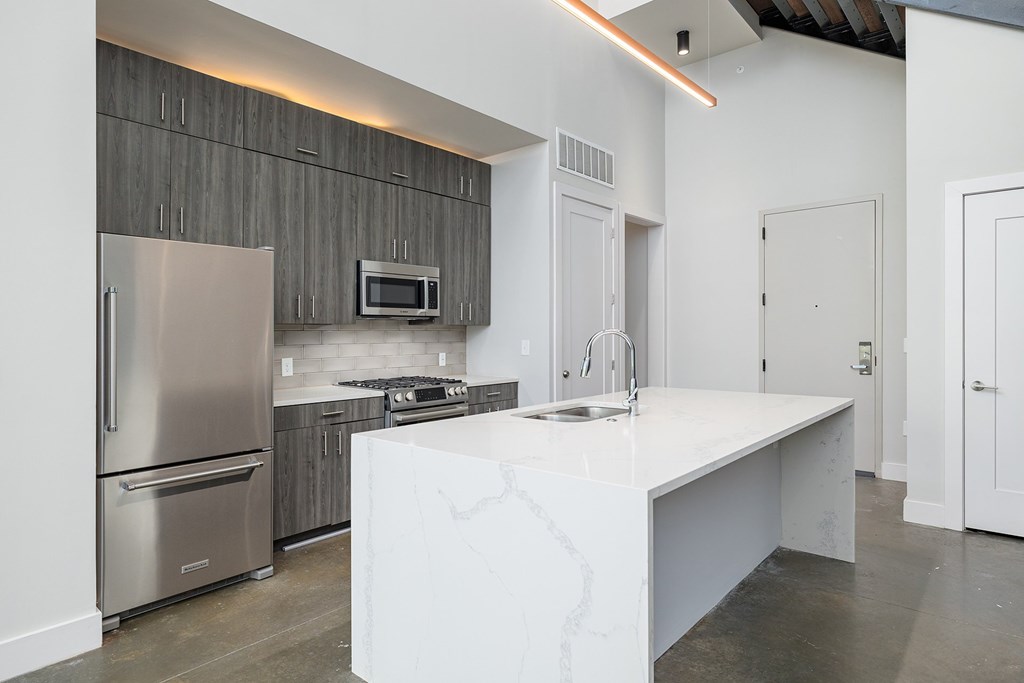 A modern kitchen with a white island in the middle.