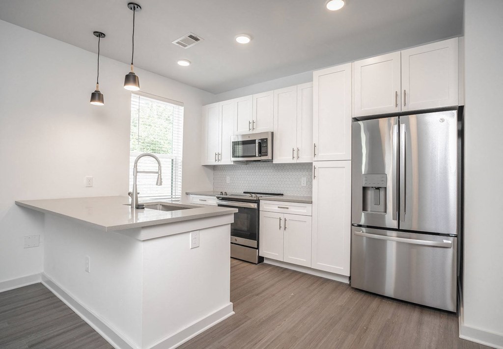 a kitchen with white cabinets and stainless steel appliances