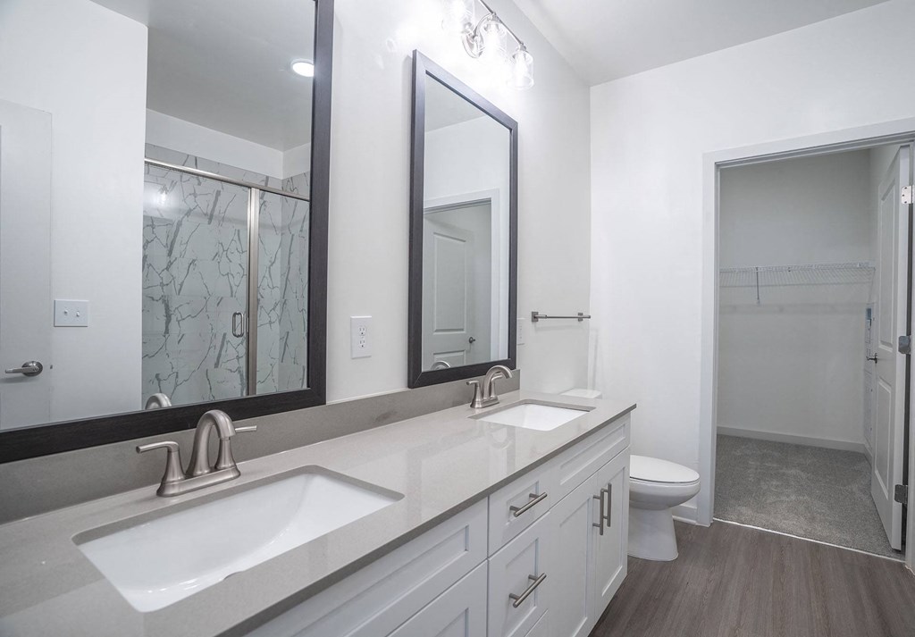 a white bathroom with two sinks and a mirror