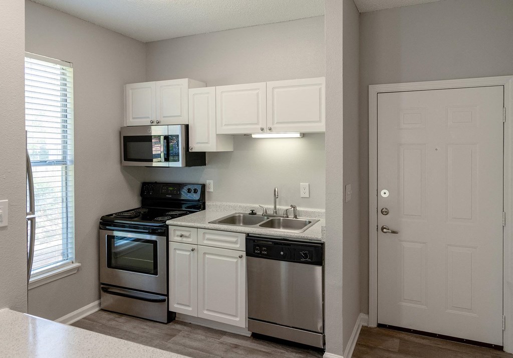 a kitchen with stainless steel appliances and white cabinets