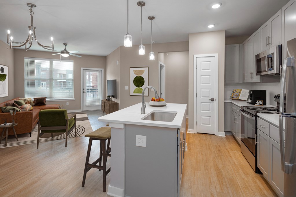 an open kitchen and living room with a white counter top